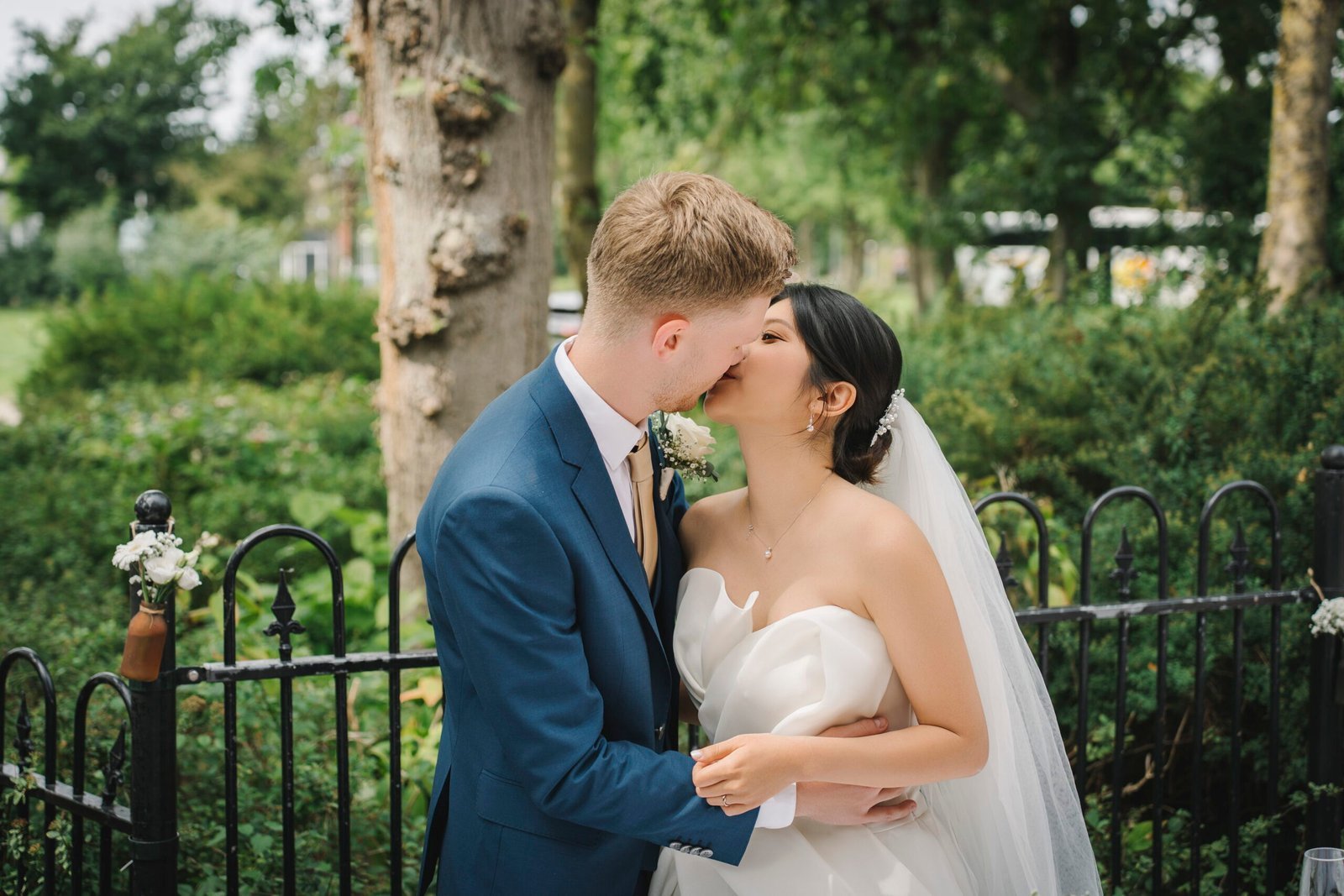 Newlyweds sharing a kiss in a garden