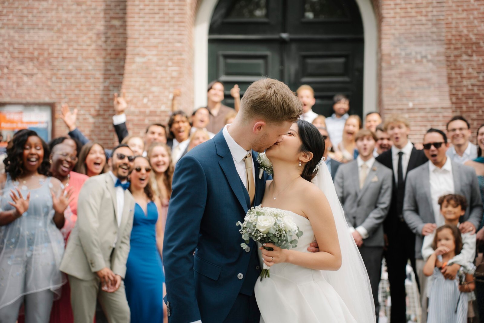 Newlyweds kissing as guests celebrate